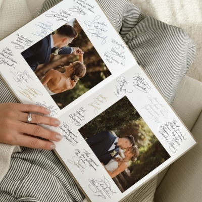 Open wedding guest book with photos and handwritten messages, layflat linen design from Inkifi