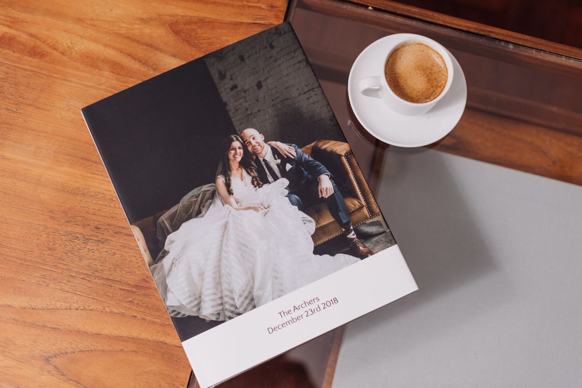 Wedding photo book on table with cup of coffee: wedding photo book working ideas