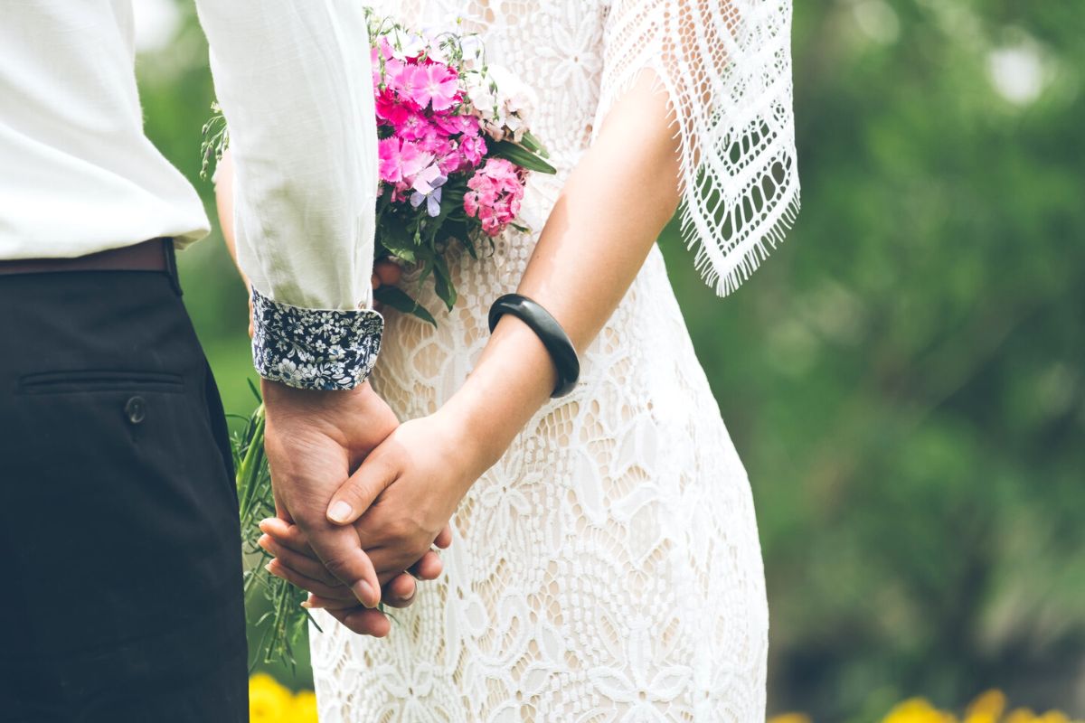 Bride and groom holding hands: close up detail for a DIY wedding album