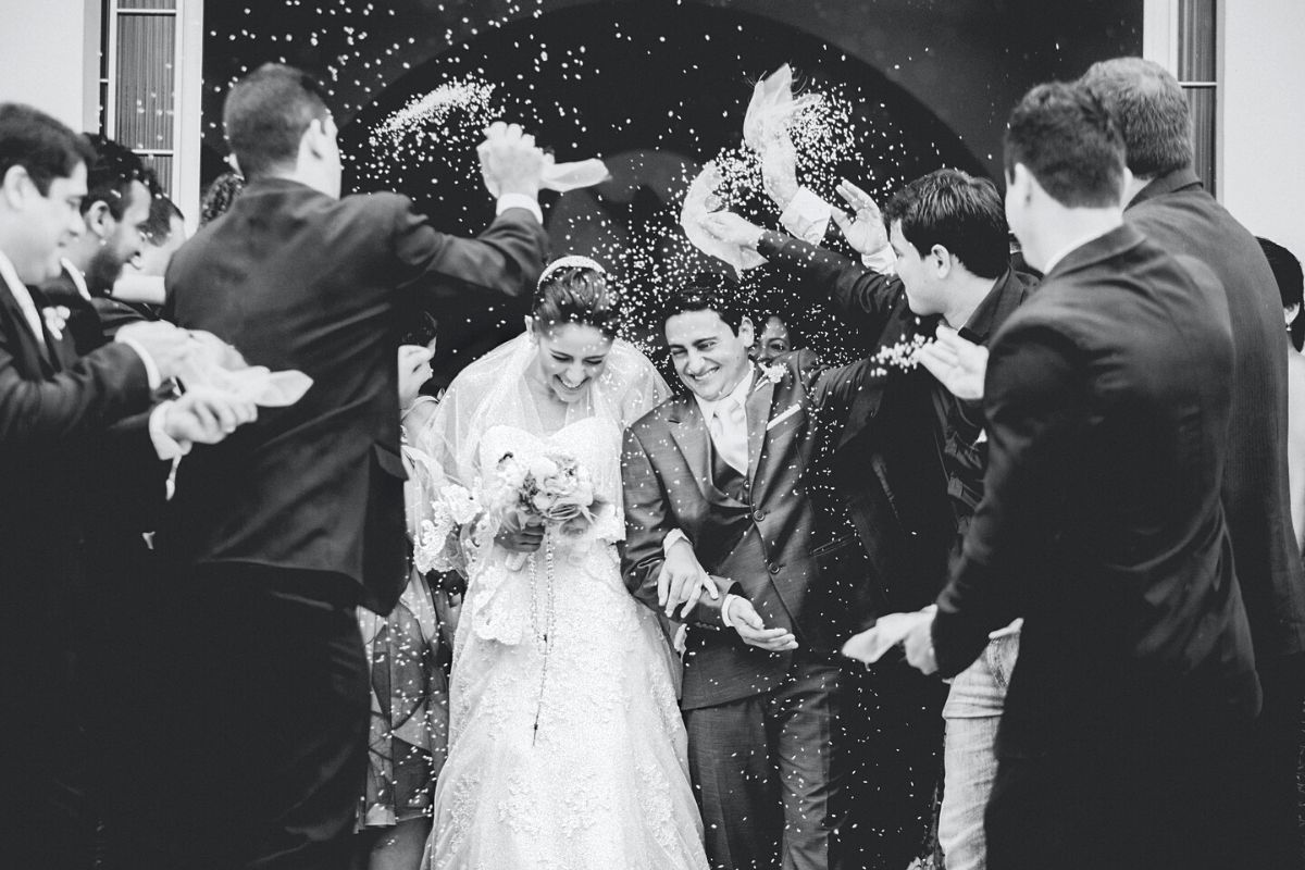 Guests throwing confetti on the married couple: wedding album cover ideas