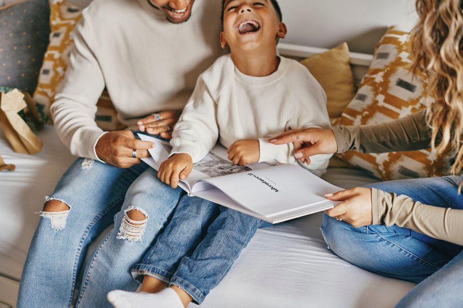 Family looking through a travel photo book and being very happy
