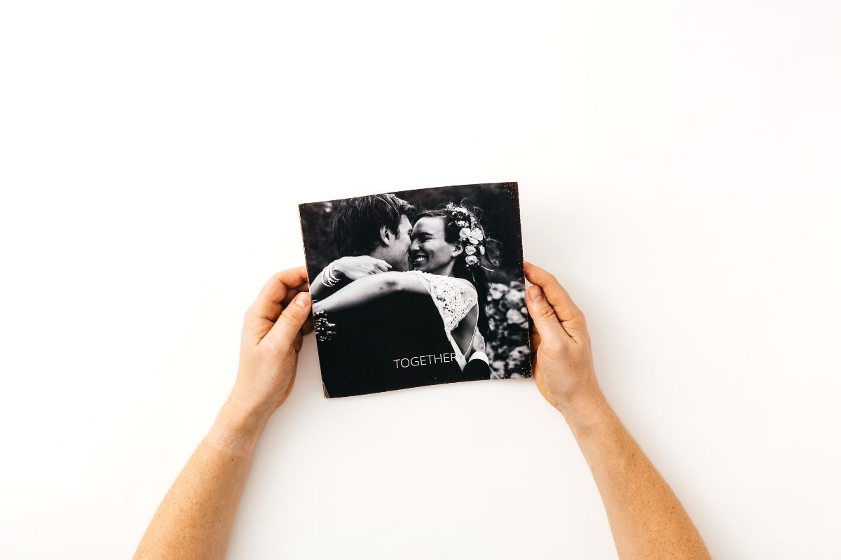 hands holding a wedding photo book: wedding album cover ideas