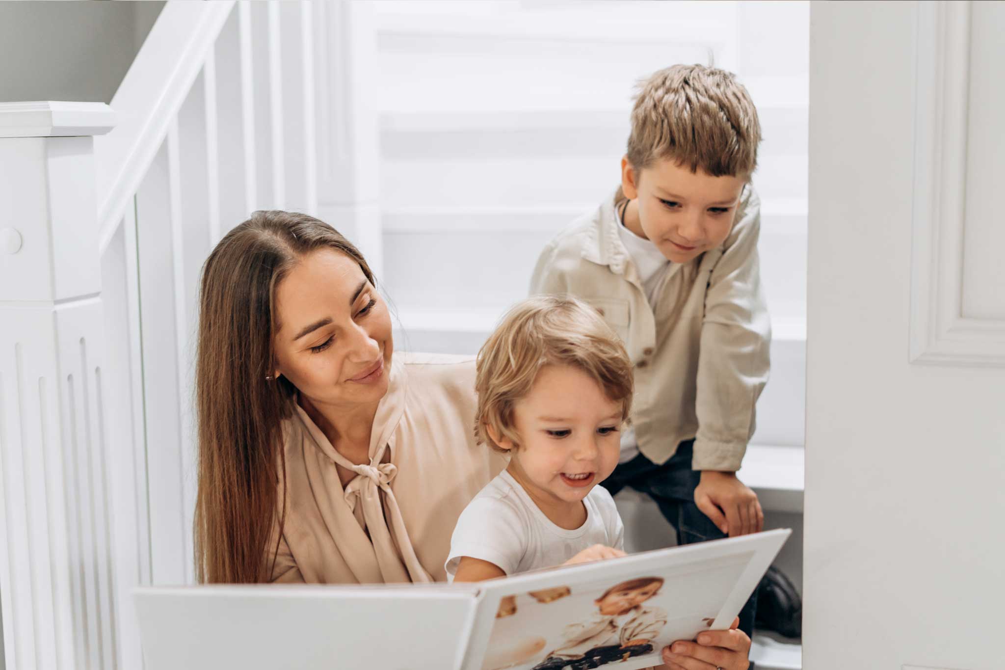 The Caption Photo Book with text being read by a mum and her childeren on the stairs