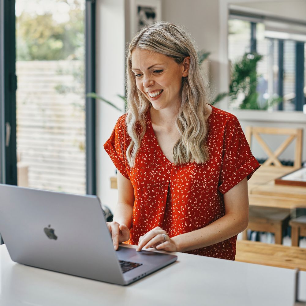 Woman selecting photos on laptop to create a personalised photo book