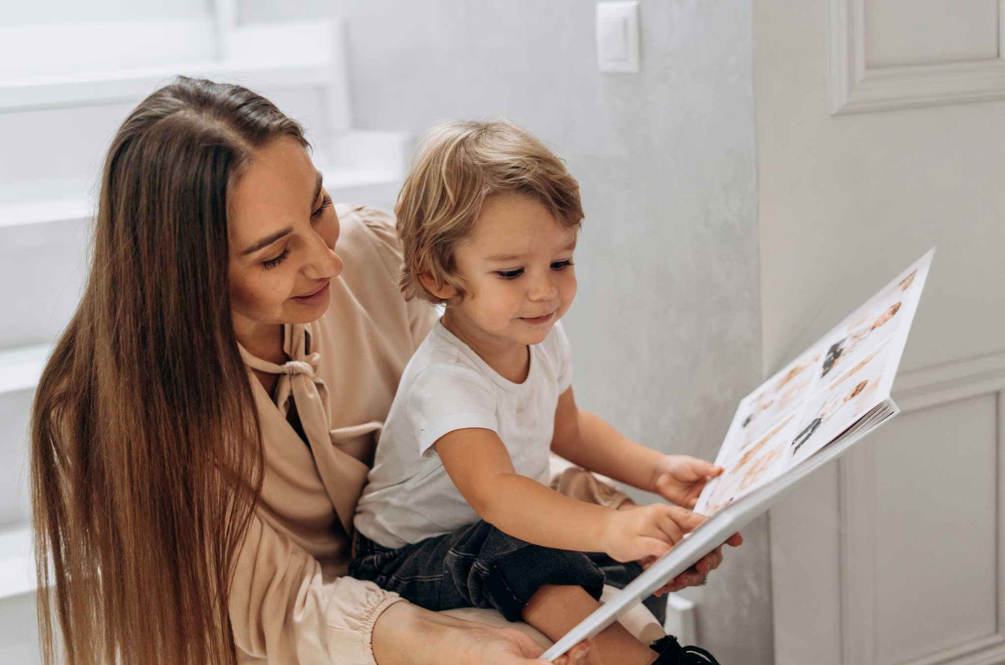 A joyful mother and toddler flip through a photo album. This AI powered photo book allows you to create a beautiful photo book in minutes